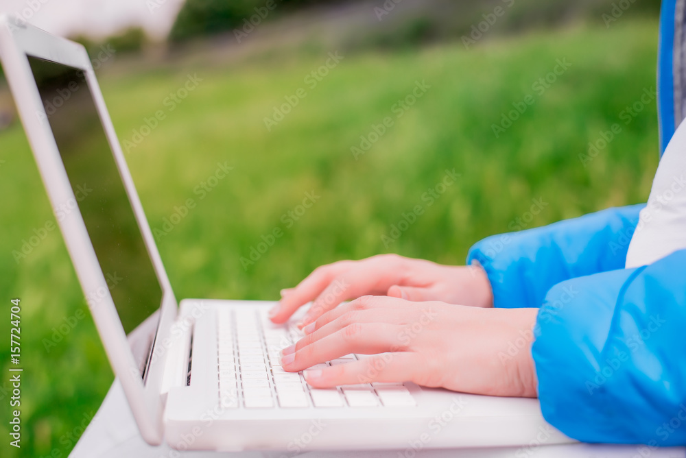 Student hands with laptop. relaxing on the park using laptop. outdoor office concept Student hands with laptop. relaxing on the park using laptop. outdoor office concept