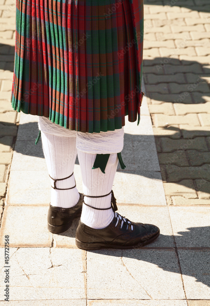 Red and green tartan Scottish kilt. Highlander wearing Scotland traditional  clothes. Bagpiper uniform - skirt and knee socks Stock Photo | Adobe Stock
