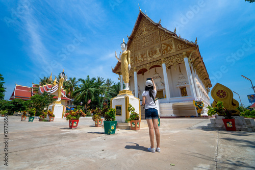 Tourism concept. Young woman taking photo on smartphone in temple at Vientiane Lao.