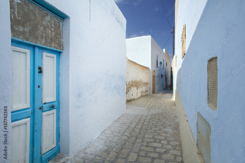 alone street with blue walls and doors in Tunisia