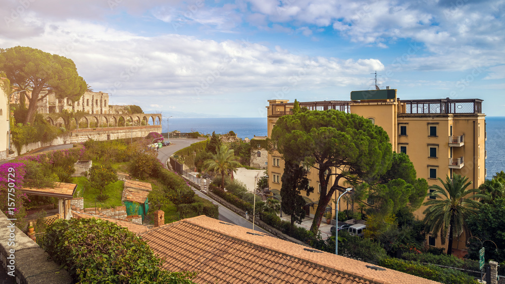 Taormina, Sicily - Beautiful view of the famous hilltop town of Taormina with palm tree, mediterranean sea and sunshine