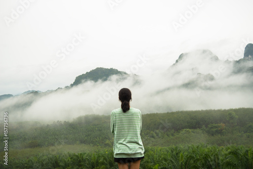 Lonely girl on the top view of hill and fog