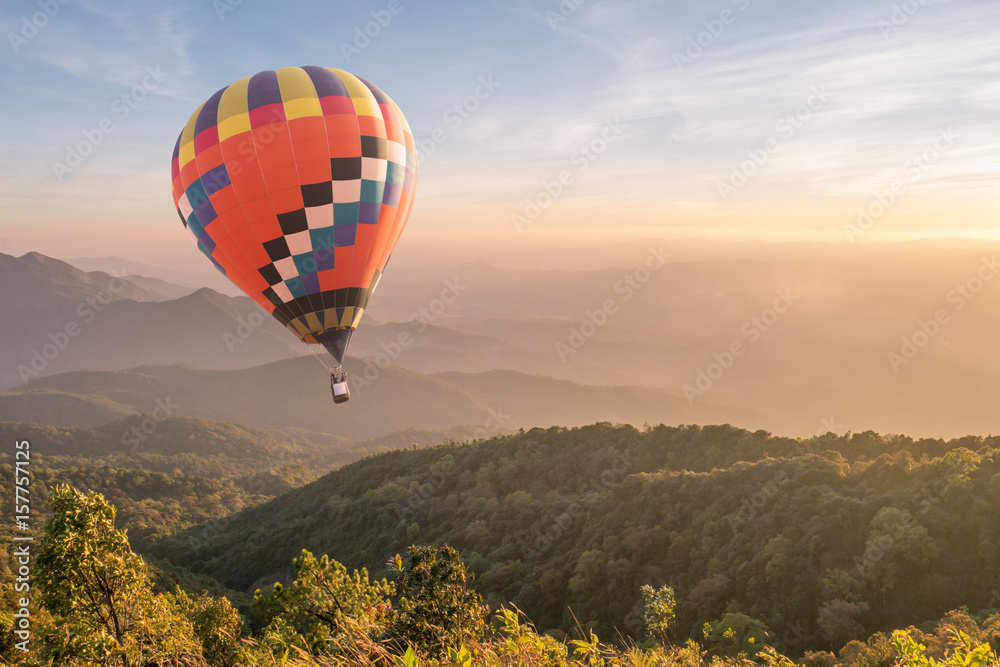 Hot air balloon over mountain at sunset