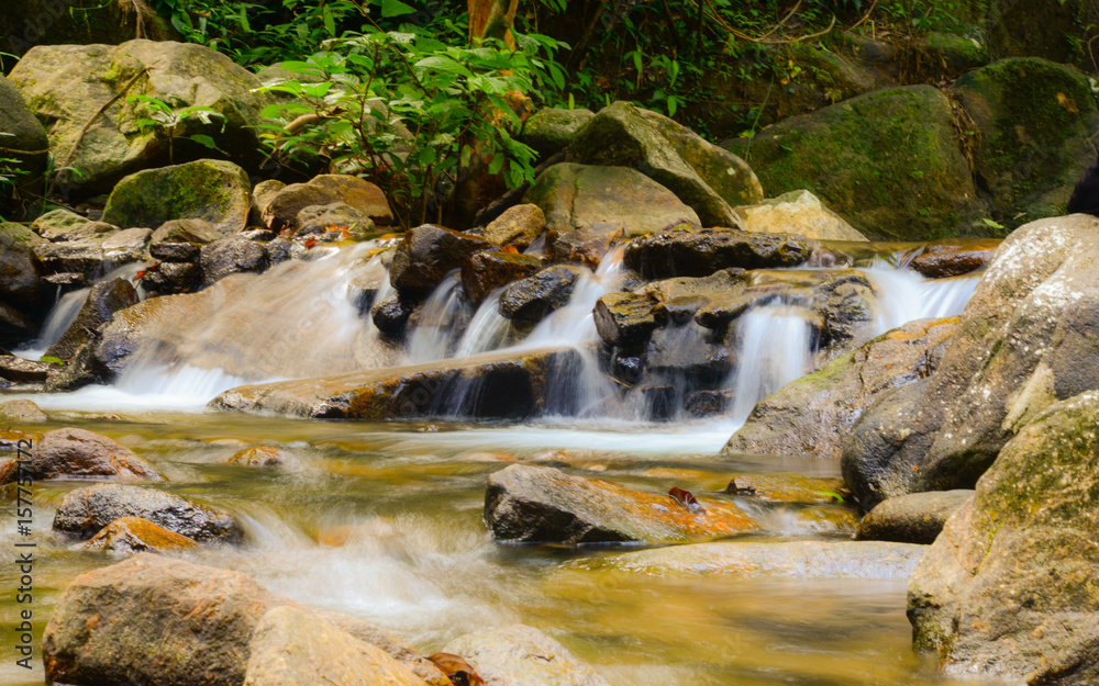 Beautiful and small waterfall in tropical forest, Thailand, long expose shutter