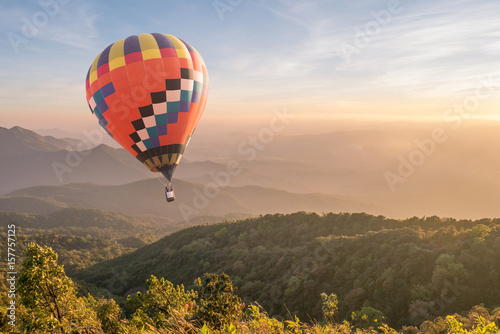 Hot air balloon over mountain at sunset