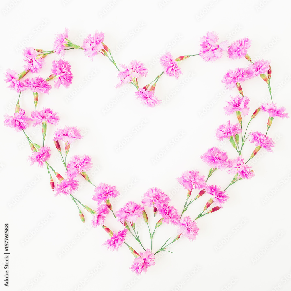 Love symbol made of pink flowers on white background. Flat lay, top view.