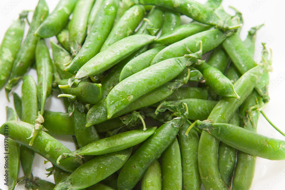 Green peas, close-up on a white background, plate Green peas, close-up on a white background, plate