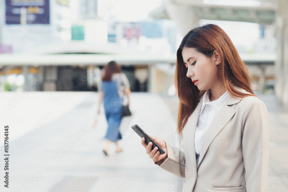 The lovely Asian business woman is using the phone to interact with business clients. The lovely Asian business woman is using the phone to interact with business clients.