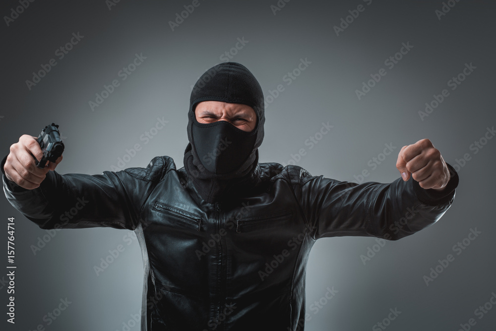 Robber with a gun, studio shot Robber with a gun, studio shot