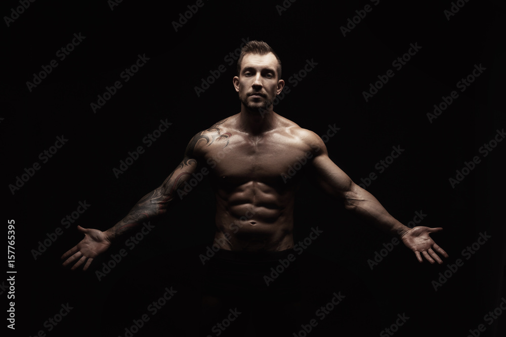 Strong athletic man showes naked muscular body Strong athletic man showes naked muscular body