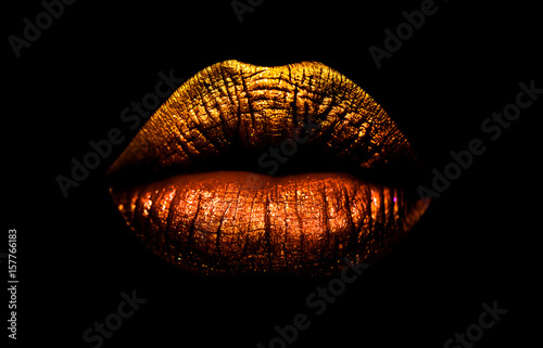 Golden brown lipstick on lips isolated on black background. Sexy lips, female mouth. Imprint lips. Luxury cosmetics for girls and women. Beautiful female lips. Female beauty concept girl photo