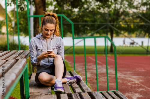 Portrait of an attractive young woman using a smartphone while sitting on a bench