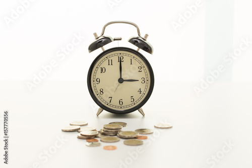 Vintage clock at three o'clock and coins