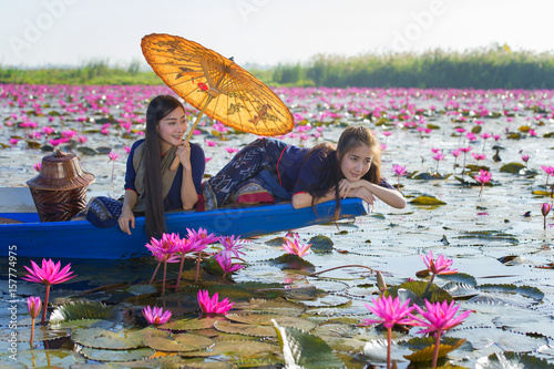 Laos women sleeping on the boat in flower lotus lake, Woman wearing traditional Thai people , Red Lotus Sea UdonThani Thailand