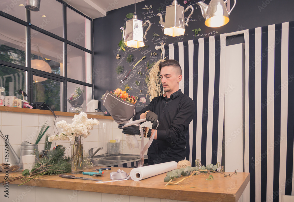 one man florist, making a bouquet, flower shop indoors one man florist, making a bouquet, flower shop indoors