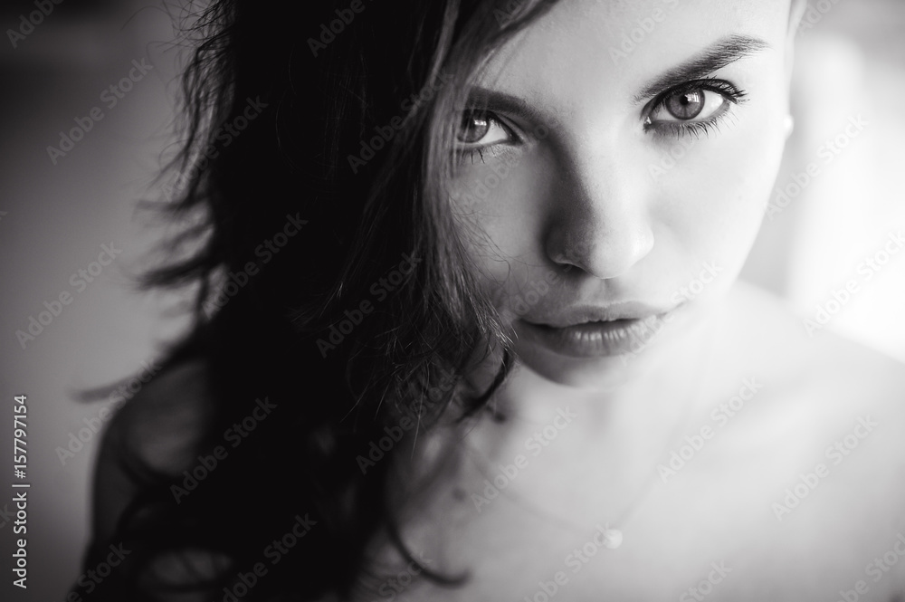 Fototapeta premium close-up portrait of a beautiful young sexy brunette girl with expressive eyes and eyes and full lips, posing for the camera