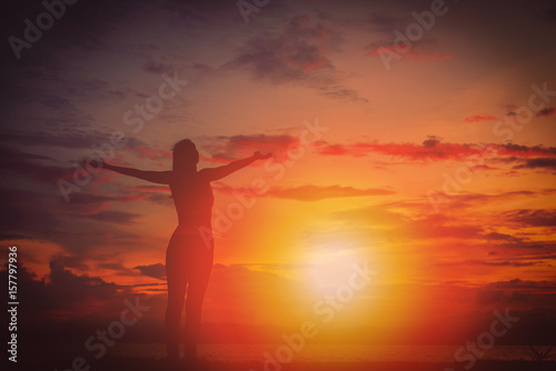 Silhouette happy woman on the beach at sunset. Vintage tone