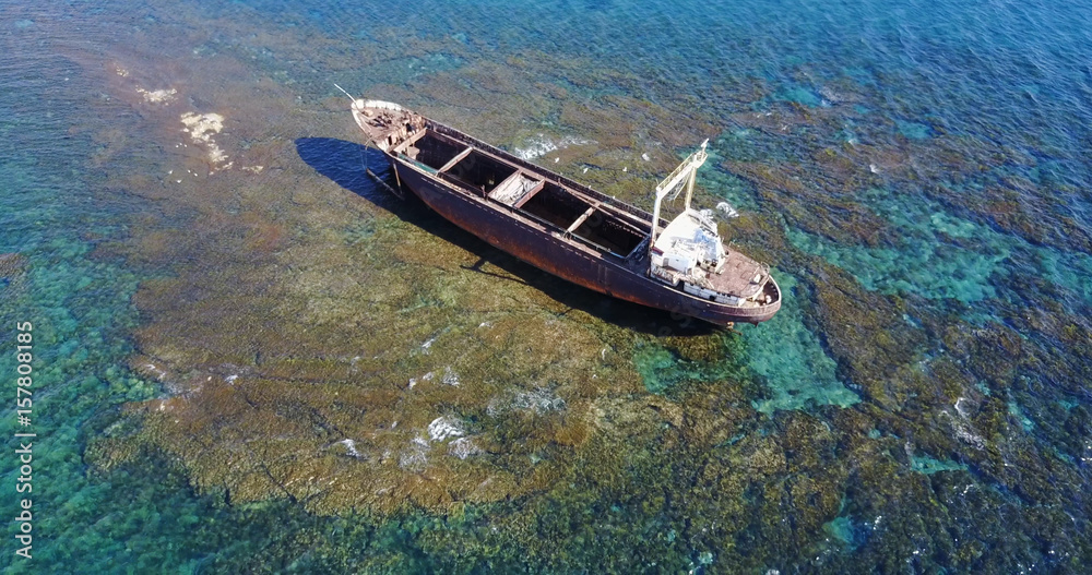 Fototapeta premium Beautiful seascape with old big, broken, rusty boat near the coast of Peyia, Cyprus. Ship graveyard. Famous landmark in the Mediterranean sea.