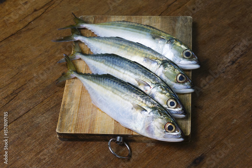 Mackerel Fish On Wooden Chopping Board With Dramatic Light And Vignette Effect