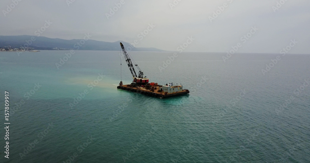Barge lifts the sand using a ladle from the bottom of the sea. Landscape shot of drone. Mediterranean Sea. Cyprus