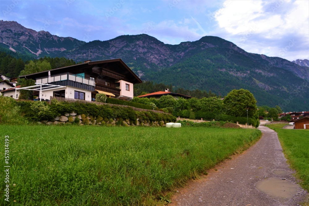 Fototapeta premium Haus mit Weg in den Bergen