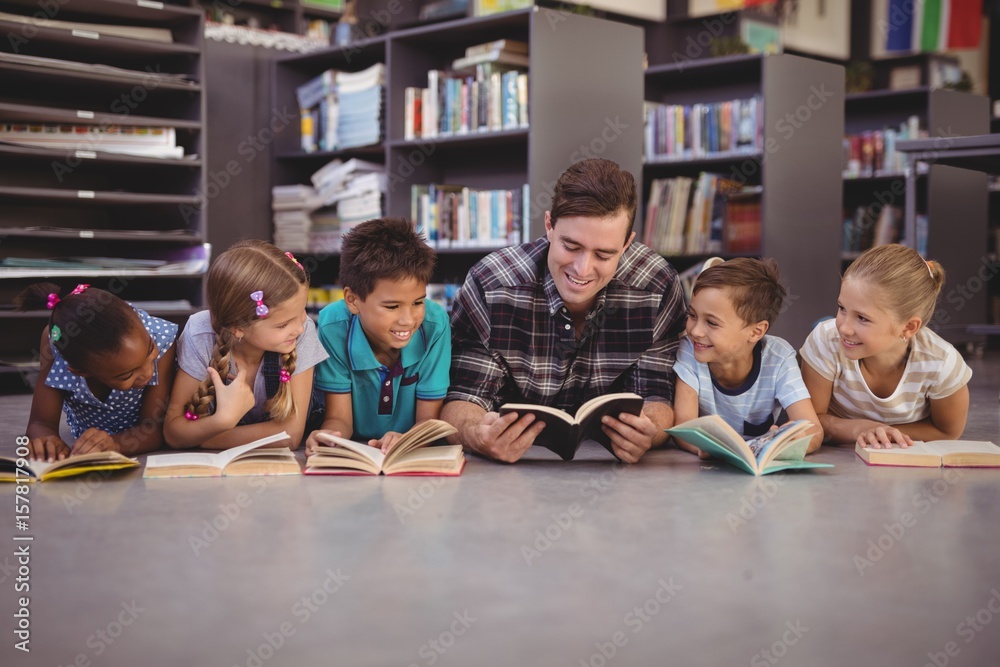 Fototapeta premium Teacher and schoolkids lying on floor 