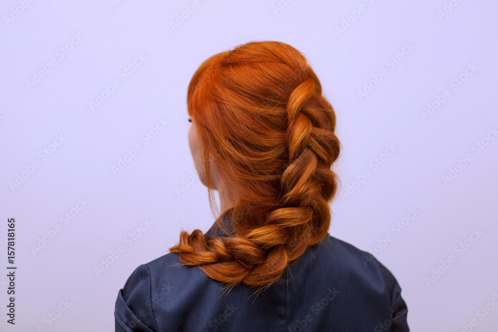 Φωτογραφία Beautiful girl with long red hair, braided with a French braid, in a beauty salon