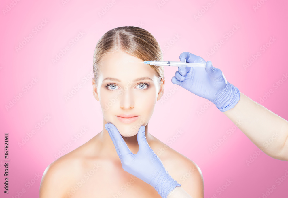 Doctor injecting in a beautiful face of a young woman. Plastic surgery concept. Doctor injecting in a beautiful face of a young woman. Plastic surgery concept.