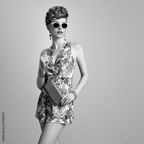 Fashion Model in Sexy Jumpsuit. Stylish Mohawk hairstyle. Beauty woman in Trendy Summer Dress, fashion Makeup, Floral Outfit.Glamour Lady,fashion pose. Playful Girl,Luxury Accessories. Black and White