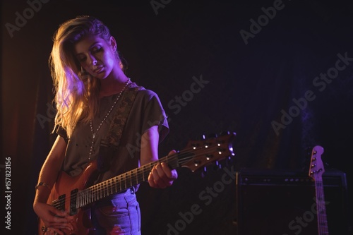 Fotografie Confident female guitarist performing in concert