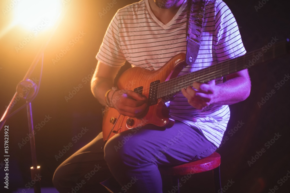 Obraz premium Mid section of singer playing guitar in nightclub