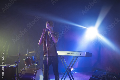 Male singer performing on illuminated stage in nightclub