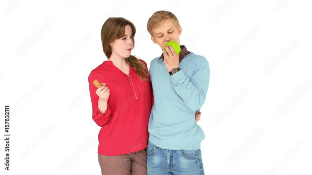 Happy young couple with fresh vegetables and fruits on a white background. They smile and up thumb Happy young couple with fresh vegetables and fruits on a white background. They smile and up thumb