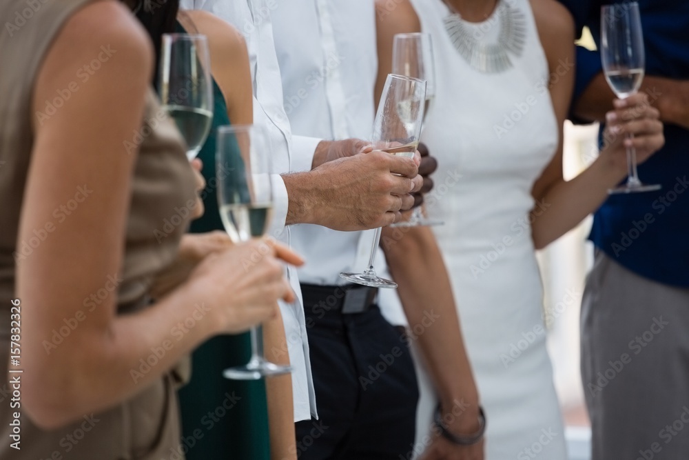 Obraz premium Mid section of friends holding wineglasses