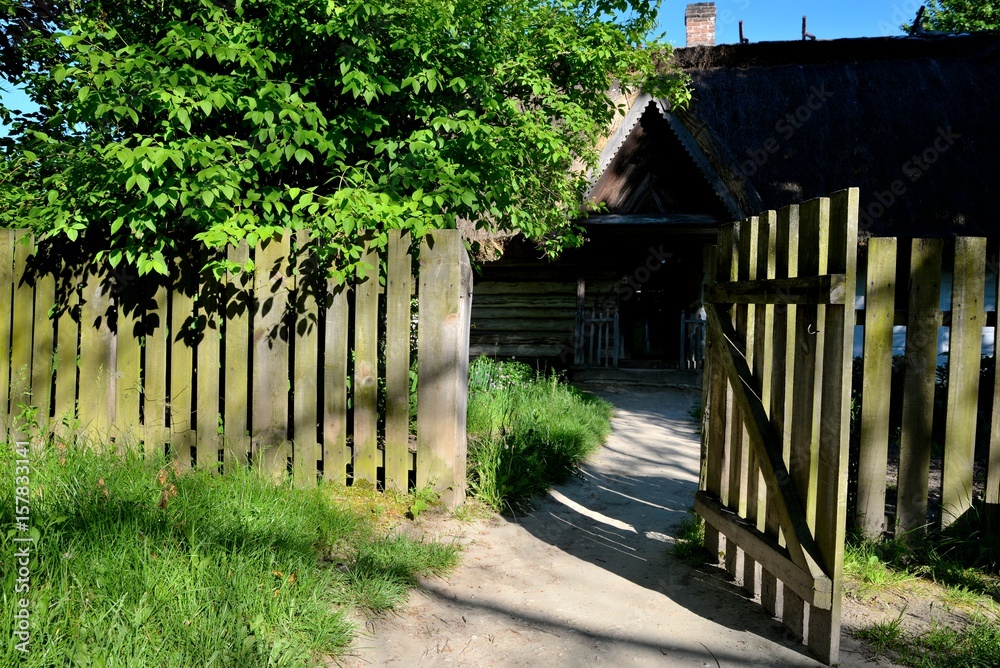 Wide open wooden gate overlooking the garden and country house