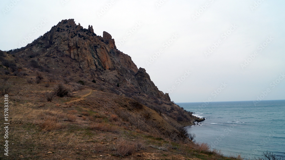 View of the black sea at the foot of the mountains under the sky in the clouds