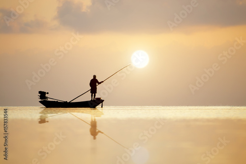 Silhouettes of fisherman at the lake, Thailand.