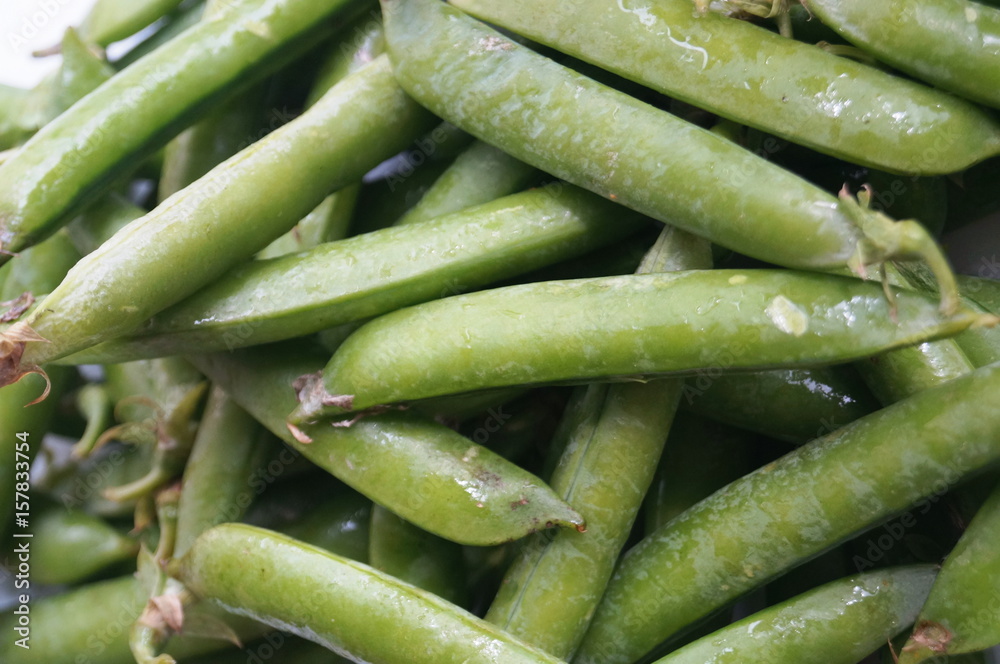 Green peas in pods are on the table Green peas in pods are on the table