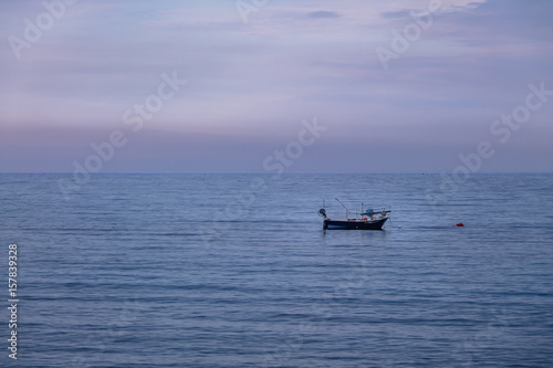 A boat in a Mediterranean beach of Ionian Sea at sunset - Bova Marina, Calabria, Italy