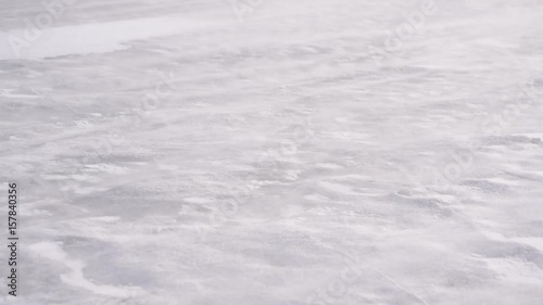 Drift snow on ice in winter blown by fierce heavy wind