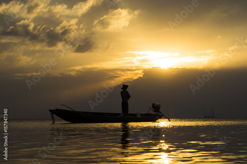 Silhouettes of fisherman at the lake with sunset, Thailand.