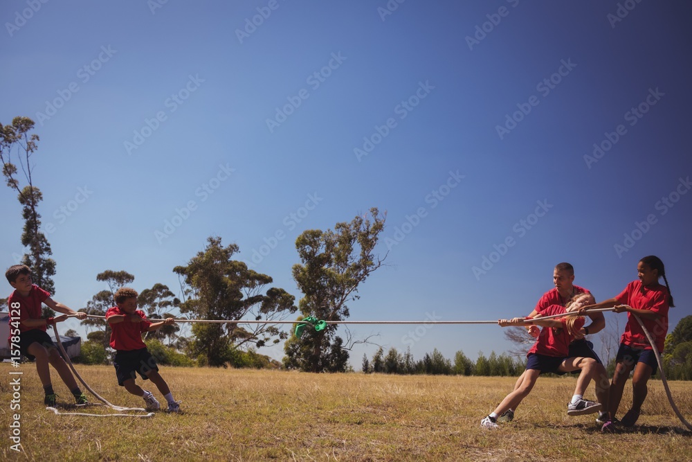 Kids playing tug of war during obstacle course training Kids playing tug of war during obstacle course training
