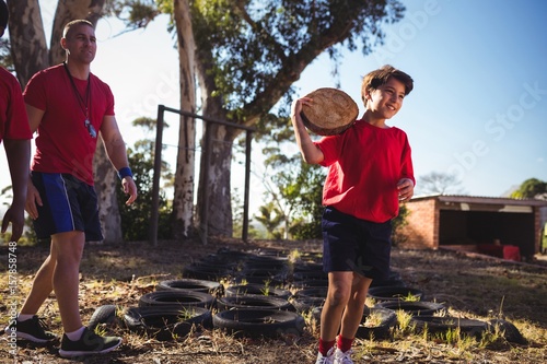 Trainer instructing a boy during obstacle course training