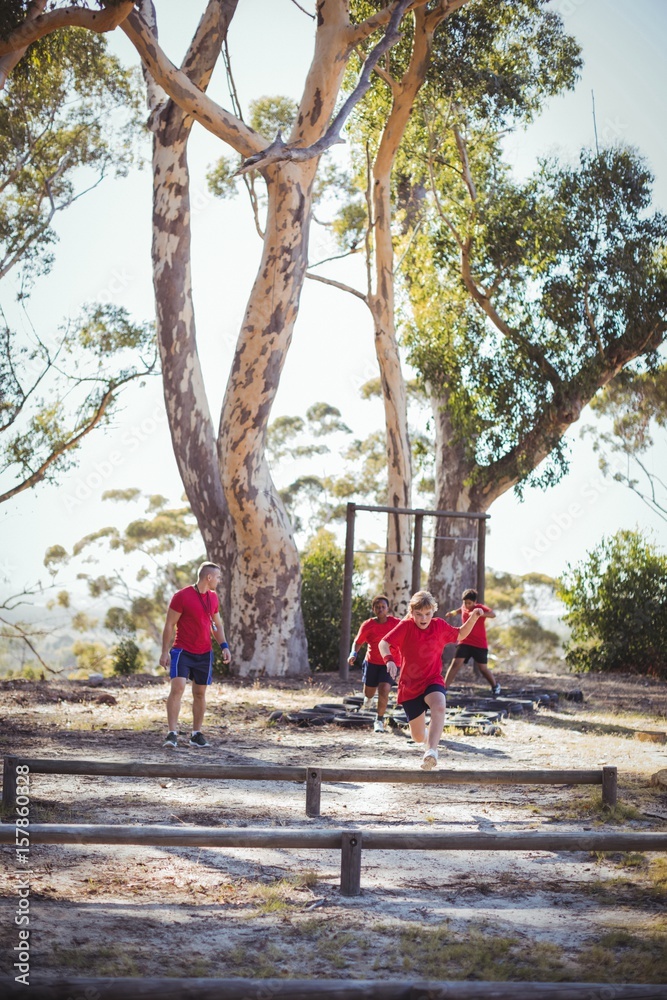 Fototapeta premium Trainer instructing kids during obstacle course training