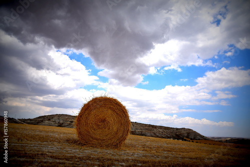 Straw bale with clouds and blue sky background 