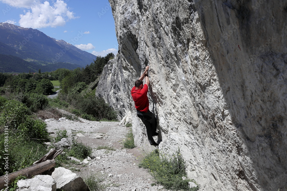 Sportler klettert an einer Felswand