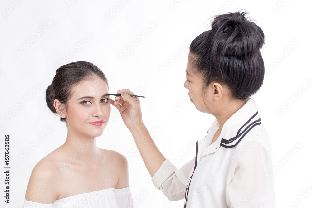 Makeup artist applies brushed at woman face. Beautiful woman face. Perfect makeup, isolated on white background, 20s year old. Makeup artist applies brushed at woman face. Beautiful woman face. Perfect makeup, isolated on white background, 20s year old.