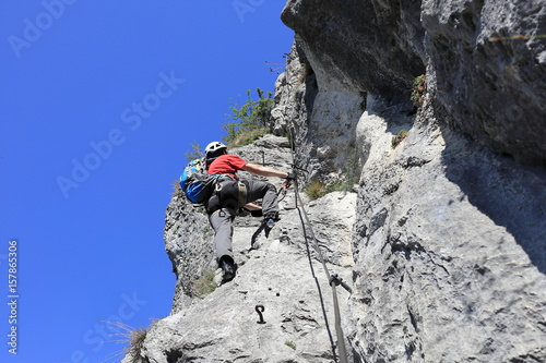 Mann klettert an einer Felswand hoch