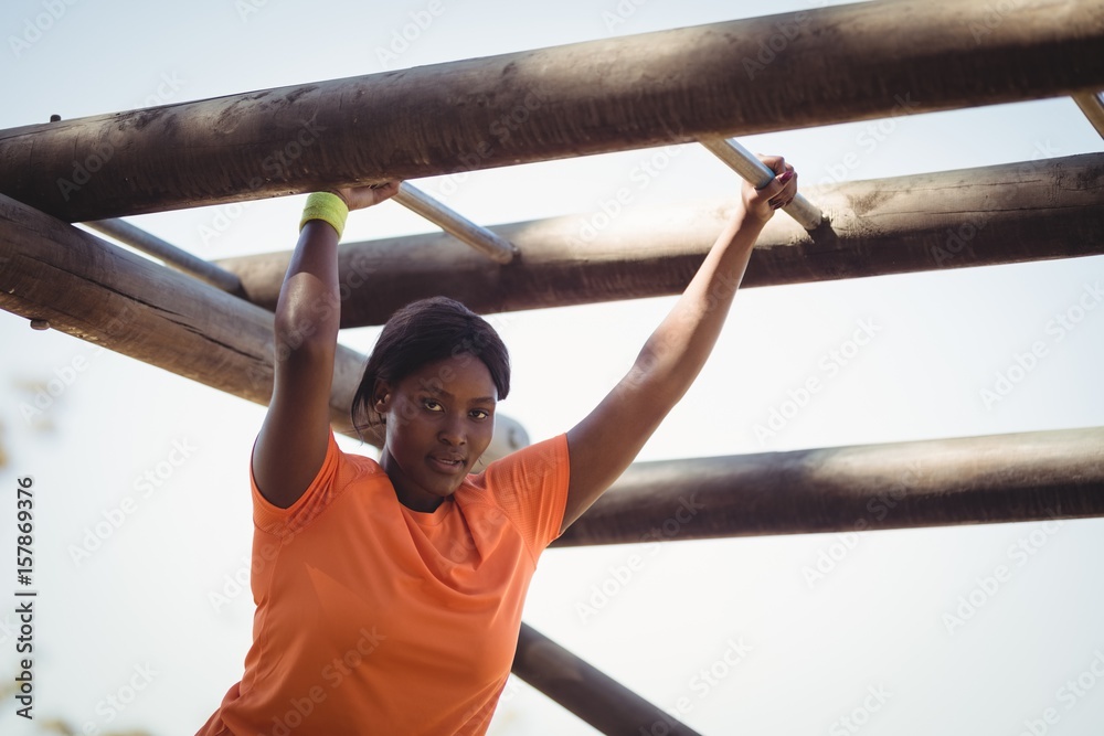 Fototapeta premium Portrait of woman exercising on horizontal bar 