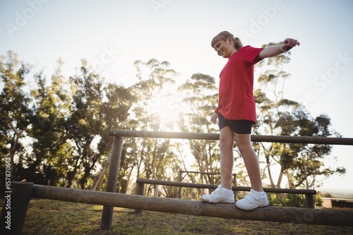 Girl walking on obstacle during obstacle course